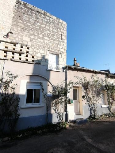 - un bâtiment en briques blanches avec une fenêtre et une porte dans l'établissement Les écuries des Princesses, à Fontevraud-l'Abbaye
