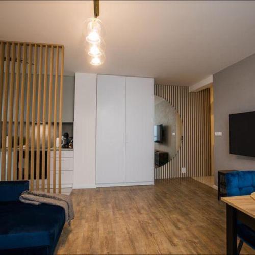 sala de estar con sofá azul y armario blanco en Apartament na wynajem 32 m2, en Bochnia