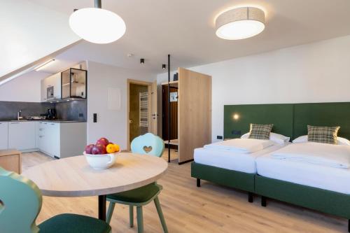 Un dormitorio con una cama y una mesa con un bol de fruta en Hapimag Ferienwohnungen St Michael, en Sankt Michael im Lungau