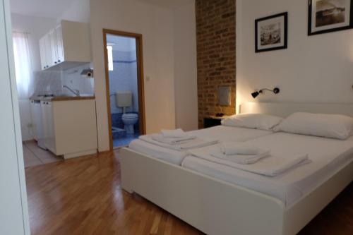 a white bed in a room with a kitchen at Apartments Golubic in Pula