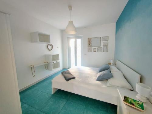 1 dormitorio con 1 cama blanca grande y suelo azul en Le Sfumature del Mare, en San Vito Chietino