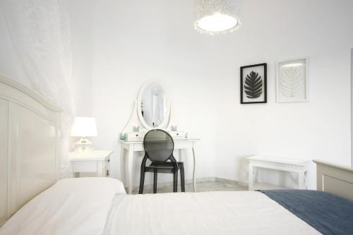 a bedroom with a bed and a desk and a mirror at Armeni Village in Oia