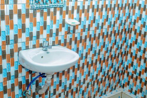 a bathroom with a sink in a mosaic wall at Fravan Eco Resort By Apogee in Ruhengeri