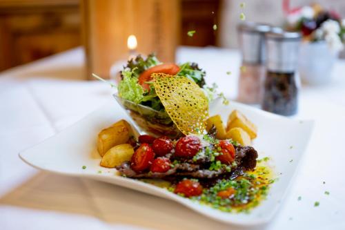 a plate of food with a salad on a table at Hapimag Ferienwohnungen St Michael in Sankt Michael im Lungau