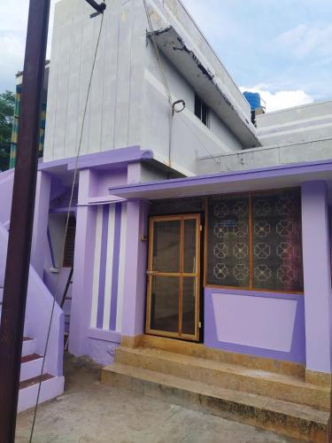 a purple house with a window and stairs at Ambai Garden Home in Ambāsamudram