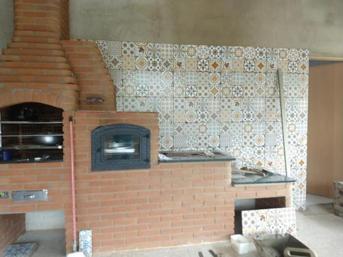 a brick pizza oven with a brick wall at Casa - Sítio da Tabi - Lagoinha-SP in Lagoinha