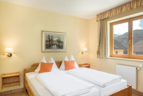 two white beds in a room with a window at Hapimag Ferienwohnungen St Michael in Sankt Michael im Lungau