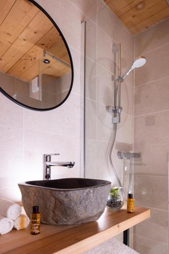 a bathroom with a stone sink and a mirror at Hôtel et Spa Le Vermont in Le Grand-Bornand