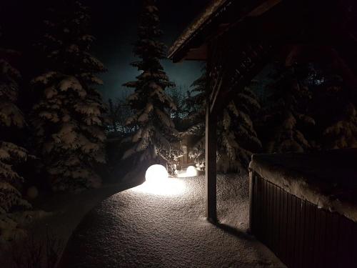 a group of lights in the snow at night at Apartamenty Pod Łysicą & SPA - przy stoku, basen, jacuzzi, sauna in Krajno Pierwsze