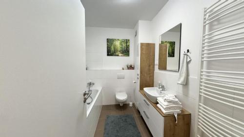 a white bathroom with a sink and a toilet at 1 room Apartment with terrace, Petržalka in Bratislava