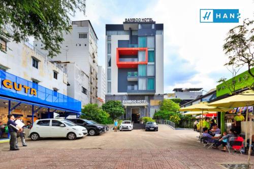 HANZ Premium Bamboo Hotel في مدينة هوشي منه: شارع المدينة فيه سيارات تقف امام المباني