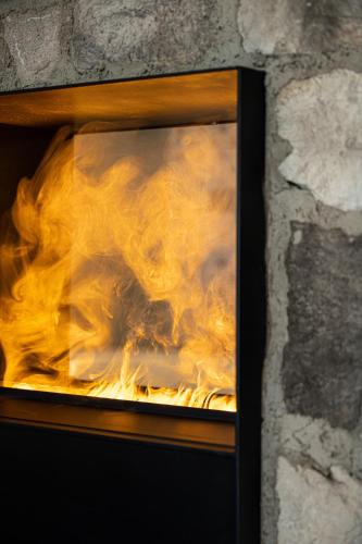 a fire in a brick oven with flames at Latemar - Hotel Suites Spa in Soraga