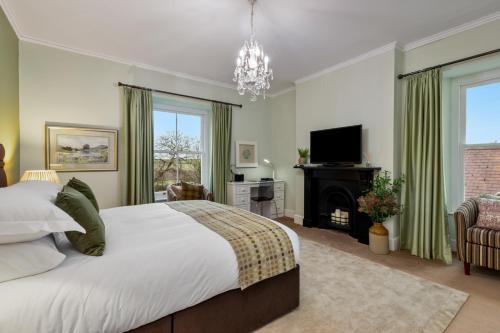 a bedroom with a large bed and a fireplace at Caemorgan Mansion in Cardigan
