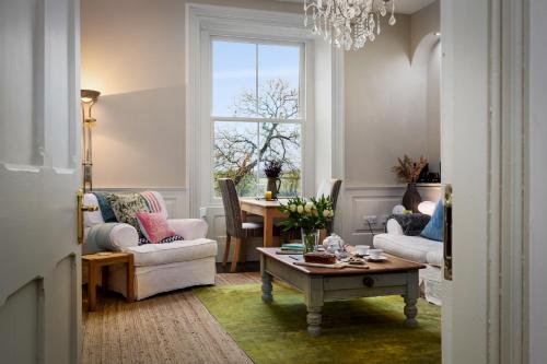 a living room with a table and chairs and a window at Caemorgan Mansion in Cardigan
