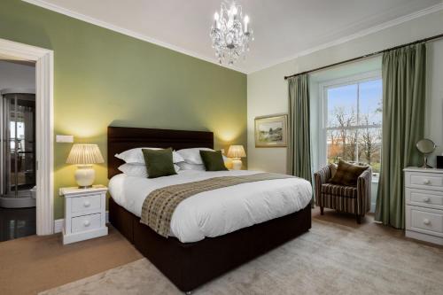 a bedroom with a large bed and a chandelier at Caemorgan Mansion in Cardigan