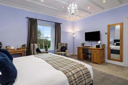 a hotel room with a bed and a television at Caemorgan Mansion in Cardigan