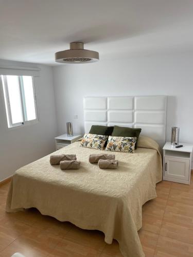 een slaapkamer met een bed met twee handdoeken erop bij Ático a 200 metros de la playa in Las Palmas de Gran Canaria