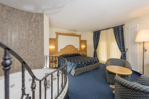 a hotel room with a bed and a bath tub at Family Hotel Andes - Only for Family in Vigo di Fassa