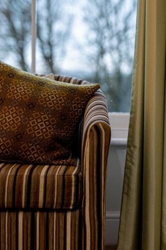 a pillow sitting on a chair in front of a window at Caemorgan Mansion in Cardigan