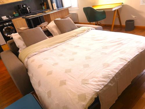uma cama grande num quarto com um sofá em Le Paisible par Picardie Homes em Soissons