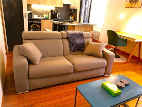 - un salon avec un canapé et une table dans l'établissement Le Paisible par Picardie Homes, à Soissons