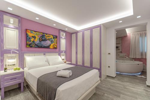a bedroom with a large bed and a bath tub at Mariet Naxos Elegant Suites in Naxos Chora