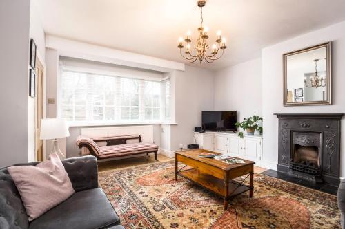 a living room with a couch and a fireplace at Railway Cottage, Port Sunlight - Stanley-Stays in Bebington