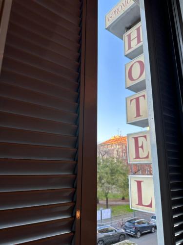 a window view of a hotel sign and a parking lot at Hotel Aspromonte in Milan