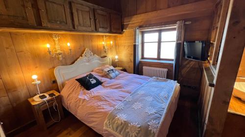 a bedroom with a bed in a room with wooden walls at l’escalade 3 in Courchevel