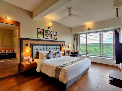 a bedroom with a large bed and a large window at Pushpam Sanskruti Resort Karjat- Pure Veg in Karjat