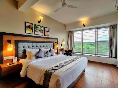 a bedroom with a large bed and a large window at Pushpam Sanskruti Resort Karjat- Pure Veg in Karjat