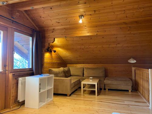 a living room with a couch and a table at EIFELCOTTAGE Family 9 in Ulmen