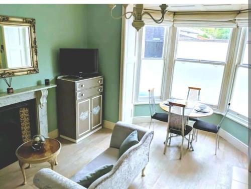 een woonkamer met een bank en een tafel en stoelen bij Beautiful Ground floor apartment with Parking, Exeter in Exeter