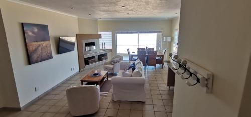 a living room with a table and chairs and a dining room at 25 Sunset View in Langstrand