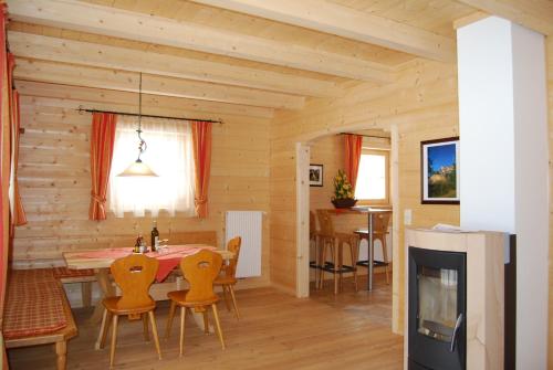 a dining room and living room with a table and chairs at Achenseer Hüttendörfl in Maurach
