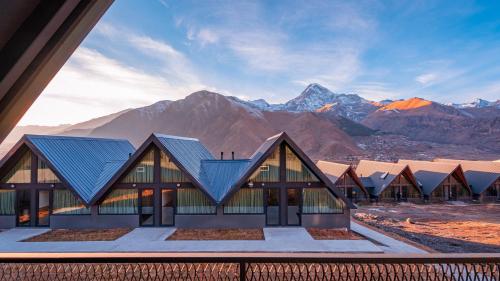 a view of a building with mountains in the background at Kazbegi View Cottages in Stepantsminda