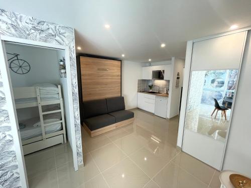 a small room with a couch and a kitchen at Grand studio en centre ville et à 50 mètres du port, climatisé in La Grande Motte