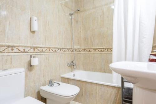 La salle de bains est pourvue de toilettes, d'un lavabo et d'une baignoire. dans l'établissement Apartamento FEDUCHY 10 min de la playa 2 baños, à Cadix