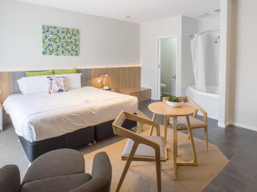 a bedroom with a bed and a table and a chair at A1 Motels and Apartments Port Fairy in Port Fairy