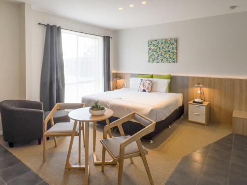 a bedroom with a bed and a table and a chair at A1 Motels and Apartments Port Fairy in Port Fairy