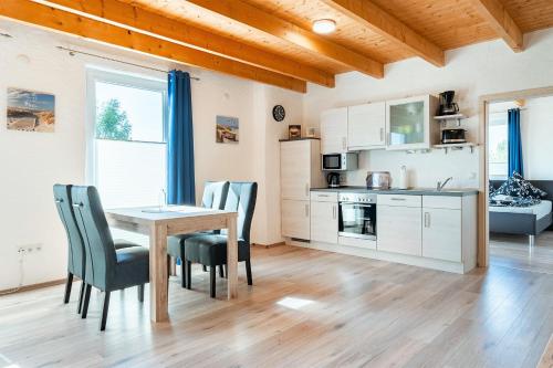 eine Küche und ein Esszimmer mit einem Tisch und Stühlen in der Unterkunft Villa Moorstern in Aurich