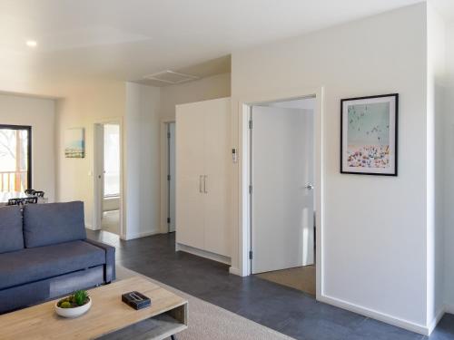 a living room with a blue couch and a table at A1 Motels and Apartments Port Fairy in Port Fairy