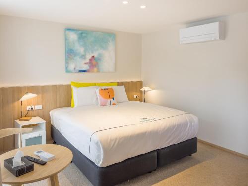 ein Schlafzimmer mit einem großen Bett und einem Tisch in der Unterkunft A1 Motels and Apartments Port Fairy in Port Fairy