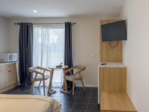 a room with a kitchen and a table and chairs at A1 Motels and Apartments Port Fairy in Port Fairy