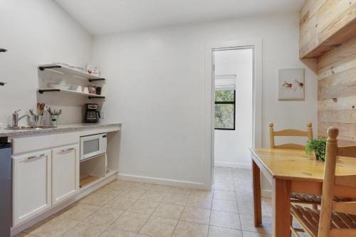 a kitchen with white cabinets and a wooden table at Wimberley Log Cabins Resort and Suites- Unit 2 in Wimberley