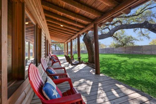 a row of chairs on a porch of a house at Wimberley Log Cabins Resort and Suites- Unit 2 in Wimberley