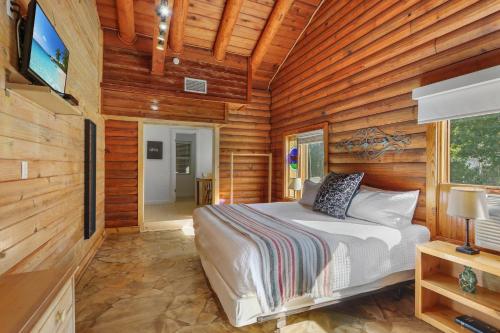 a bedroom with a bed in a room with wooden walls at Wimberley Log Cabins Resort and Suites- Unit 4 in Wimberley