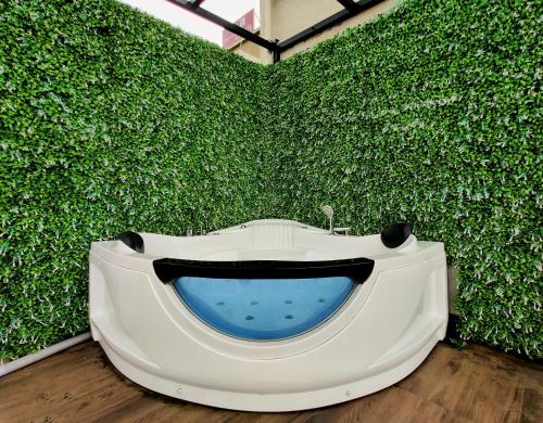 a green wall with a bathtub in front of it at Pushpam Sanskruti Resort Karjat- Pure Veg in Karjat