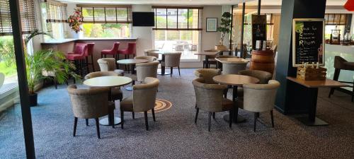 a restaurant with tables and chairs in a room at Hostellerie Saint Vincent Beauvais Aeroport in Beauvais