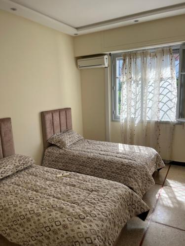 - 2 lits dans une chambre avec fenêtre dans l'établissement Superbe appartement Patio, à Rabat